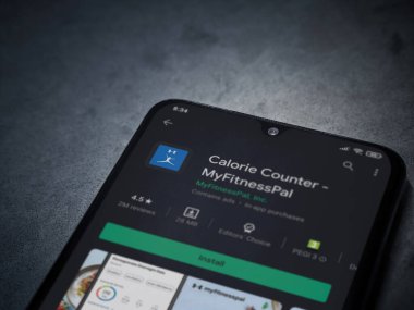 Lod, Israel - 8 Temmuz 2020: MyFitnessPal uygulama oyun mağazası sayfası koyu mermer taşlı arka planda siyah bir cep telefonunun görüntüsü. Üst görünüm düzlüğü kopyalama alanı ile yatıyordu.
