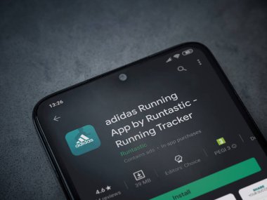 Lod, Israel - 8 Temmuz 2020: Adidas Running app playshop sayfası koyu mermer taşlı arka planda siyah bir cep telefonunun ekranında. Üst görünüm düzlüğü kopyalama alanı ile yatıyordu.