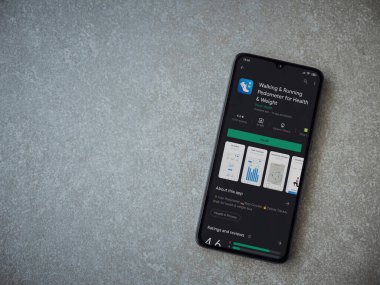 Lod, Israel - 8 Temmuz 2020: Yürüyen Pedometre uygulaması oyun mağazası sayfası seramik taş zemin üzerinde siyah bir cep telefonu görüntüsü. Üst görünüm düzlüğü kopyalama alanı ile yatıyordu.