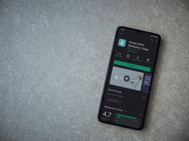 Lod, Israel - 8 Temmuz 2020: Basit Alışkanlık uygulaması oyun mağazası sayfası seramik taş zemin üzerinde siyah bir cep telefonu görüntüsü. Üst görünüm düzlüğü kopyalama alanı ile yatıyordu.