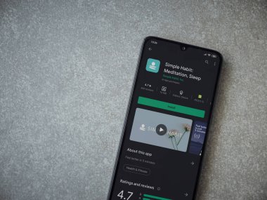 Lod, Israel - 8 Temmuz 2020: Basit Alışkanlık uygulaması oyun mağazası sayfası seramik taş zemin üzerinde siyah bir cep telefonu görüntüsü. Üst görünüm düzlüğü kopyalama alanı ile yatıyordu.