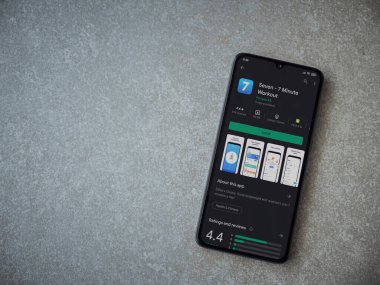 Lod, Israel - 8 Temmuz 2020: Seramik taş zemin üzerinde siyah bir cep telefonunun sergilendiği yedi uygulama oyun mağazası sayfası. Üst görünüm düzlüğü kopyalama alanı ile yatıyordu.