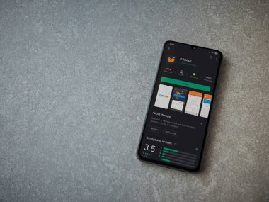 Lod, Israel - 8 Temmuz 2020: Meuhedet Sağlık Hizmetleri uygulama oyun mağazası sayfası seramik taş zemin üzerinde siyah bir cep telefonu görüntüsü. Üst görünüm düzlüğü kopyalama alanı ile yatıyordu.