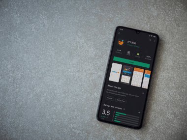 Lod, Israel - 8 Temmuz 2020: Meuhedet Sağlık Hizmetleri uygulama oyun mağazası sayfası seramik taş zemin üzerinde siyah bir cep telefonu görüntüsü. Üst görünüm düzlüğü kopyalama alanı ile yatıyordu.