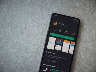 Lod, Israel - 8 Temmuz 2020: Meuhedet Sağlık Hizmetleri uygulama oyun mağazası sayfası seramik taş zemin üzerinde siyah bir cep telefonu görüntüsü. Üst görünüm düzlüğü kopyalama alanı ile yatıyordu.