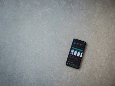 Lod, Israel - 8 Temmuz 2020: Maccbi Sağlık Hizmetleri uygulama oyun mağazası sayfası seramik taş zemin üzerinde siyah bir cep telefonu görüntüsü. Üst görünüm düzlüğü kopyalama alanı ile yatıyordu.