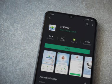 Lod, Israel - 8 Temmuz 2020: Leumit Health Services uygulama oyun mağazası sayfası seramik taş zemin üzerinde siyah bir cep telefonu görüntüsü. Üst görünüm düzlüğü kopyalama alanı ile yatıyordu.