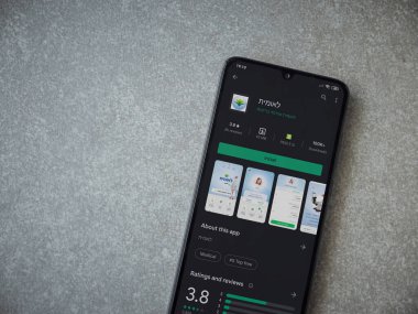 Lod, Israel - 8 Temmuz 2020: Leumit Health Services uygulama oyun mağazası sayfası seramik taş zemin üzerinde siyah bir cep telefonu görüntüsü. Üst görünüm düzlüğü kopyalama alanı ile yatıyordu.