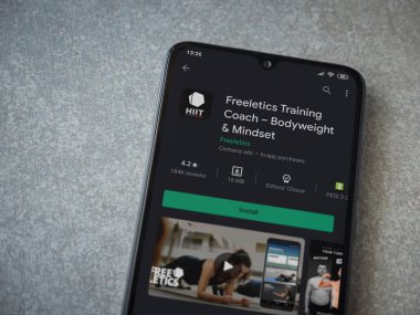 Lod, Israel - 8 Temmuz 2020: Freeletics Eğitim Koçu uygulama oyun mağazası sayfası seramik taş zemin üzerinde siyah bir cep telefonu görüntüsü. Üst görünüm düzlüğü kopyalama alanı ile yatıyordu.