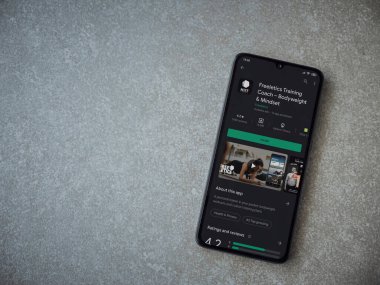 Lod, Israel - 8 Temmuz 2020: Freeletics Eğitim Koçu uygulama oyun mağazası sayfası seramik taş zemin üzerinde siyah bir cep telefonu görüntüsü. Üst görünüm düzlüğü kopyalama alanı ile yatıyordu.