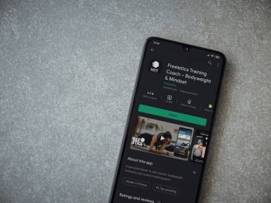 Lod, Israel - 8 Temmuz 2020: Freeletics Eğitim Koçu uygulama oyun mağazası sayfası seramik taş zemin üzerinde siyah bir cep telefonu görüntüsü. Üst görünüm düzlüğü kopyalama alanı ile yatıyordu.