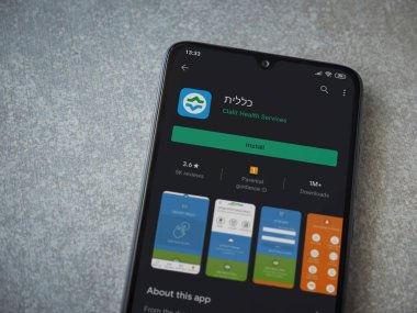 Lod, Israel - 8 Temmuz 2020: Clalit Sağlık Hizmetleri uygulama oyun mağazası sayfası seramik taş zemin üzerinde siyah bir cep telefonu görüntüsü. Üst görünüm düzlüğü kopyalama alanı ile yatıyordu.