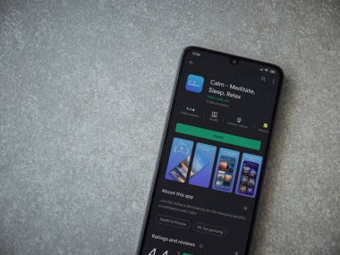 Lod, Israel - 8 Temmuz 2020: Seramik taş zemin üzerinde siyah bir cep telefonunun sergilendiği sakin uygulama oyun mağazası sayfası. Üst görünüm düzlüğü kopyalama alanı ile yatıyordu.