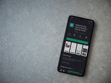 Lod, Israel - 8 Temmuz 2020: Adidas Running app playshop sayfasında seramik taş zemin üzerinde siyah bir cep telefonu sergilenmektedir. Üst görünüm düzlüğü kopyalama alanı ile yatıyordu.