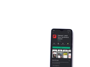 Lod, Israel - 8 Temmuz 2020: Flipboard uygulama oyun mağazası sayfası beyaz arkaplanda izole edilmiş siyah bir cep telefonu ekranında. Üst görünüm düzlüğü kopyalama alanı ile yatıyordu.