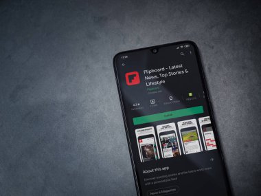 Lod, Israel - 8 Temmuz 2020: Flipboard uygulaması oyun mağazası sayfası koyu mermer taştan arka planda siyah bir cep telefonunun ekranında. Üst görünüm düzlüğü kopyalama alanı ile yatıyordu.