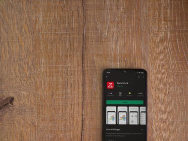 Lod, Israel - 8 Temmuz 2020: Roborock uygulama oyun mağazası sayfası ahşap arka planda siyah bir cep telefonunun ekranında. Üst görünüm düzlüğü kopyalama alanı ile yatıyordu.