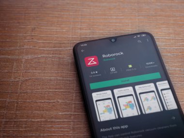 Lod, Israel - 8 Temmuz 2020: Roborock uygulama oyun mağazası sayfası ahşap arka planda siyah bir cep telefonunun ekranında. Üst görünüm düzlüğü kopyalama alanı ile yatıyordu.