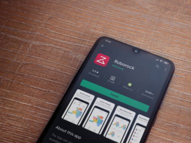 Lod, Israel - 8 Temmuz 2020: Roborock uygulama oyun mağazası sayfası ahşap arka planda siyah bir cep telefonunun ekranında. Üst görünüm düzlüğü kopyalama alanı ile yatıyordu.