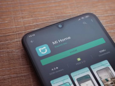 Lod, Israel - 8 Temmuz 2020: Mi Home uygulaması oyun mağazası sayfası ahşap arka planda siyah bir cep telefonunun ekranında. Üst görünüm düzlüğü kopyalama alanı ile yatıyordu.