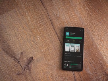 Lod, Israel - 8 Temmuz 2020: Mi Home uygulaması oyun mağazası sayfası ahşap arka planda siyah bir cep telefonunun ekranında. Üst görünüm düzlüğü kopyalama alanı ile yatıyordu.