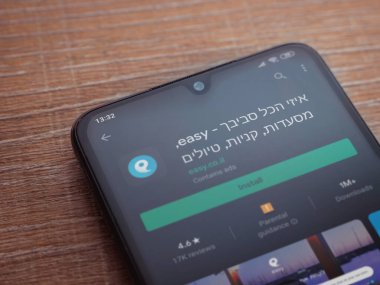Lod, Israel - 8 Temmuz 2020: Ahşap arka planda siyah bir cep telefonu ekranında basit bir uygulama oyun mağazası sayfası. Üst görünüm düzlüğü kopyalama alanı ile yatıyordu.