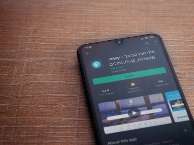 Lod, Israel - 8 Temmuz 2020: Ahşap arka planda siyah bir cep telefonu ekranında basit bir uygulama oyun mağazası sayfası. Üst görünüm düzlüğü kopyalama alanı ile yatıyordu.