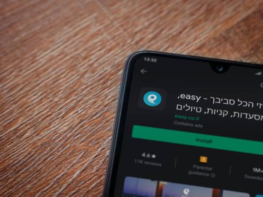 Lod, Israel - 8 Temmuz 2020: Ahşap arka planda siyah bir cep telefonu ekranında basit bir uygulama oyun mağazası sayfası. Üst görünüm düzlüğü kopyalama alanı ile yatıyordu.