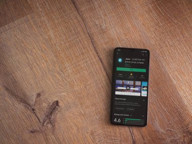 Lod, Israel - 8 Temmuz 2020: Ahşap arka planda siyah bir cep telefonu ekranında basit bir uygulama oyun mağazası sayfası. Üst görünüm düzlüğü kopyalama alanı ile yatıyordu.