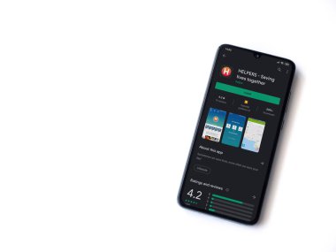 Lod, Israel - 8 Temmuz 2020: Yardımcı uygulamalar beyaz arka planda izole edilmiş siyah bir cep telefonunun ekranında oyun mağazası sayfası. Üst görünüm düzlüğü kopyalama alanı ile yatıyordu.