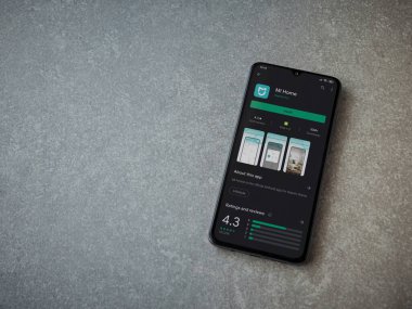 Lod, Israel - 8 Temmuz 2020: Mi Home uygulaması oyun mağazası sayfası seramik taş zemin üzerinde siyah bir cep telefonu görüntüsü. Üst görünüm düzlüğü kopyalama alanı ile yatıyordu.