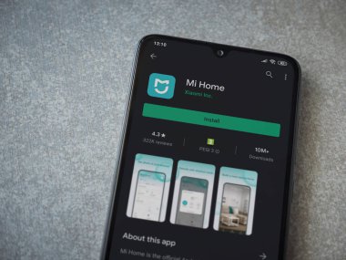 Lod, Israel - 8 Temmuz 2020: Mi Home uygulaması oyun mağazası sayfası seramik taş zemin üzerinde siyah bir cep telefonu görüntüsü. Üst görünüm düzlüğü kopyalama alanı ile yatıyordu.
