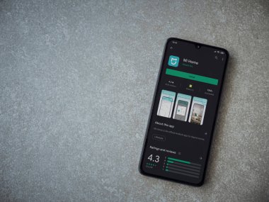 Lod, Israel - 8 Temmuz 2020: Mi Home uygulaması oyun mağazası sayfası seramik taş zemin üzerinde siyah bir cep telefonu görüntüsü. Üst görünüm düzlüğü kopyalama alanı ile yatıyordu.