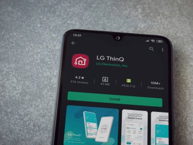Lod, Israel - 8 Temmuz 2020: LG ThinQ uygulama oyun mağazası sayfasında seramik taş zemin üzerinde siyah bir cep telefonu görüntüsü. Üst görünüm düzlüğü kopyalama alanı ile yatıyordu.