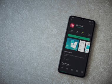 Lod, Israel - 8 Temmuz 2020: LG ThinQ uygulama oyun mağazası sayfasında seramik taş zemin üzerinde siyah bir cep telefonu görüntüsü. Üst görünüm düzlüğü kopyalama alanı ile yatıyordu.