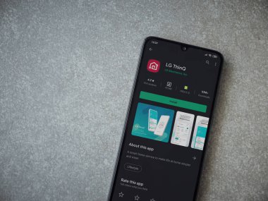 Lod, Israel - 8 Temmuz 2020: LG ThinQ uygulama oyun mağazası sayfasında seramik taş zemin üzerinde siyah bir cep telefonu görüntüsü. Üst görünüm düzlüğü kopyalama alanı ile yatıyordu.