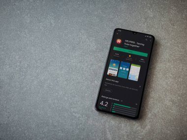 Lod, Israel - 8 Temmuz 2020: Yardımcı uygulamalar seramik taş zemin üzerinde siyah bir cep telefonu ekranında oyun mağazası sayfası. Üst görünüm düzlüğü kopyalama alanı ile yatıyordu.