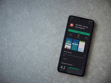 Lod, Israel - 8 Temmuz 2020: Yardımcı uygulamalar seramik taş zemin üzerinde siyah bir cep telefonu ekranında oyun mağazası sayfası. Üst görünüm düzlüğü kopyalama alanı ile yatıyordu.