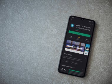 Lod, Israel - 8 Temmuz 2020: Seramik taş zemin üzerinde siyah bir cep telefonunun sergilendiği basit bir uygulama oyun mağazası sayfası. Üst görünüm düzlüğü kopyalama alanı ile yatıyordu.