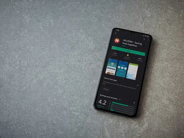 Lod, Israel - 8 Temmuz 2020: Yardımcı uygulamalar seramik taş zemin üzerinde siyah bir cep telefonu ekranında oyun mağazası sayfası. Üst görünüm düzlüğü kopyalama alanı ile yatıyordu.