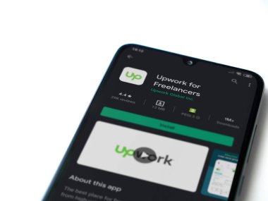 Lod, Israel - 8 Temmuz 2020: Freelancers uygulama oyun mağazası sayfası için beyaz arkaplanda izole edilmiş siyah bir cep telefonu görüntüsü. Üst görünüm düzlüğü kopyalama alanı ile yatıyordu.