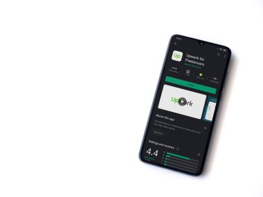 Lod, Israel - 8 Temmuz 2020: Freelancers uygulama oyun mağazası sayfası için beyaz arkaplanda izole edilmiş siyah bir cep telefonu görüntüsü. Üst görünüm düzlüğü kopyalama alanı ile yatıyordu.