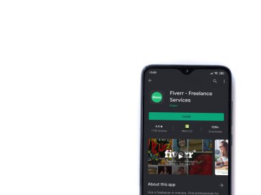 Lod, Israel - 8 Temmuz 2020: Fiverr uygulama oyun mağazası sayfası beyaz arkaplanda izole edilmiş siyah bir cep telefonu ekranında. Üst görünüm düzlüğü kopyalama alanı ile yatıyordu.