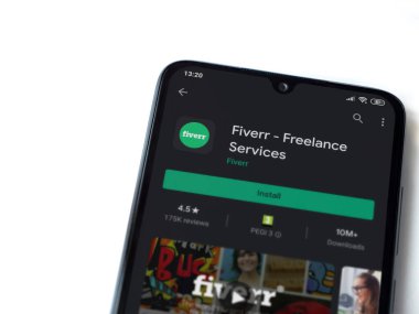 Lod, Israel - 8 Temmuz 2020: Fiverr uygulama oyun mağazası sayfası beyaz arkaplanda izole edilmiş siyah bir cep telefonu ekranında. Üst görünüm düzlüğü kopyalama alanı ile yatıyordu.