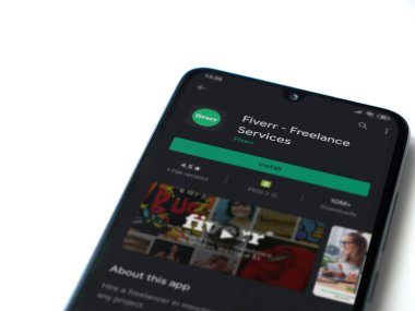 Lod, Israel - 8 Temmuz 2020: Fiverr uygulama oyun mağazası sayfası beyaz arkaplanda izole edilmiş siyah bir cep telefonu ekranında. Üst görünüm düzlüğü kopyalama alanı ile yatıyordu.