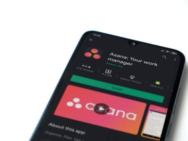 Lod, Israel - 8 Temmuz 2020: Asana uygulama oyun mağazası sayfası beyaz arkaplanda izole edilmiş siyah bir cep telefonu ekranında. Üst görünüm düzlüğü kopyalama alanı ile yatıyordu.