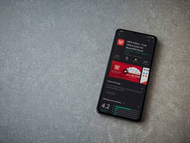 Lod, Israel - 8 Temmuz 2020: WPS Office uygulama oyun mağazası sayfası seramik taş zemin üzerinde siyah bir cep telefonu görüntüsü. Üst görünüm düzlüğü kopyalama alanı ile yatıyordu.