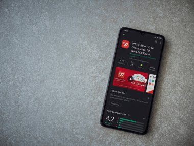 Lod, Israel - 8 Temmuz 2020: WPS Office uygulama oyun mağazası sayfası seramik taş zemin üzerinde siyah bir cep telefonu görüntüsü. Üst görünüm düzlüğü kopyalama alanı ile yatıyordu.