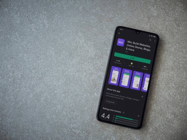 Lod, Israel - 8 Temmuz 2020: Wix uygulaması oyun mağazası sayfası seramik taş zemin üzerinde siyah bir cep telefonu görüntüsü. Üst görünüm düzlüğü kopyalama alanı ile yatıyordu.