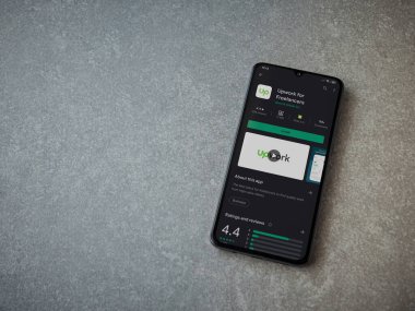 Lod, Israel - 8 Temmuz 2020: Freelancers uygulaması için seramik taş zemin üzerinde siyah bir cep telefonu sergilenen bir oyun mağazası sayfası. Üst görünüm düzlüğü kopyalama alanı ile yatıyordu.